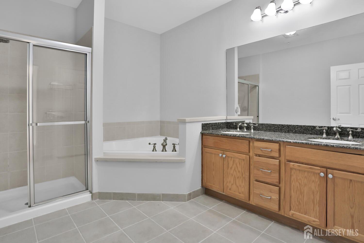 325 Regency Place Woodbridge, NJ 07095 - Photo 21 of 30 a spacious bathroom with a shower sink and mirror