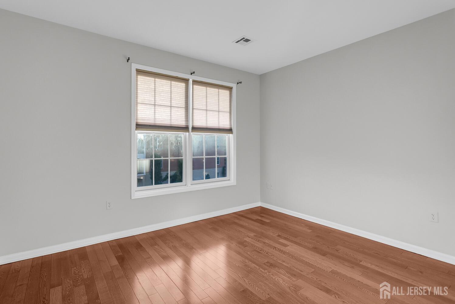 325 Regency Place Woodbridge, NJ 07095 - Photo 26 of 30 an empty room with wooden floor and windows