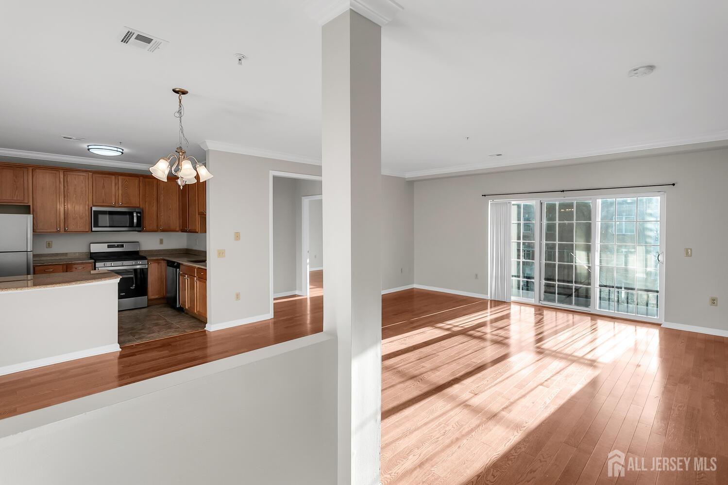 325 Regency Place Woodbridge, NJ 07095 - Photo 10 of 30 a open kitchen with granite countertop a stove top oven a sink dishwasher a dining table and chairs with wooden floor