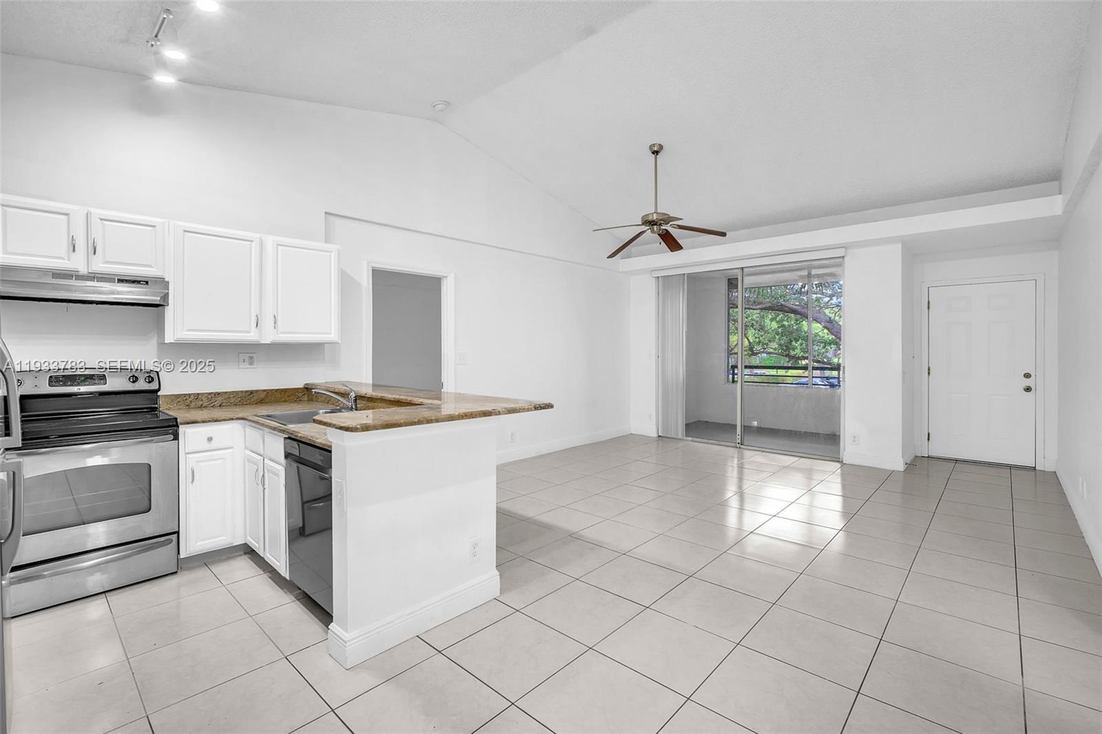 811 Lyons Road, Unit 20203 Coconut Creek, FL 33063 - Photo 11 of 23 a kitchen with a stove a sink and a refrigerator
