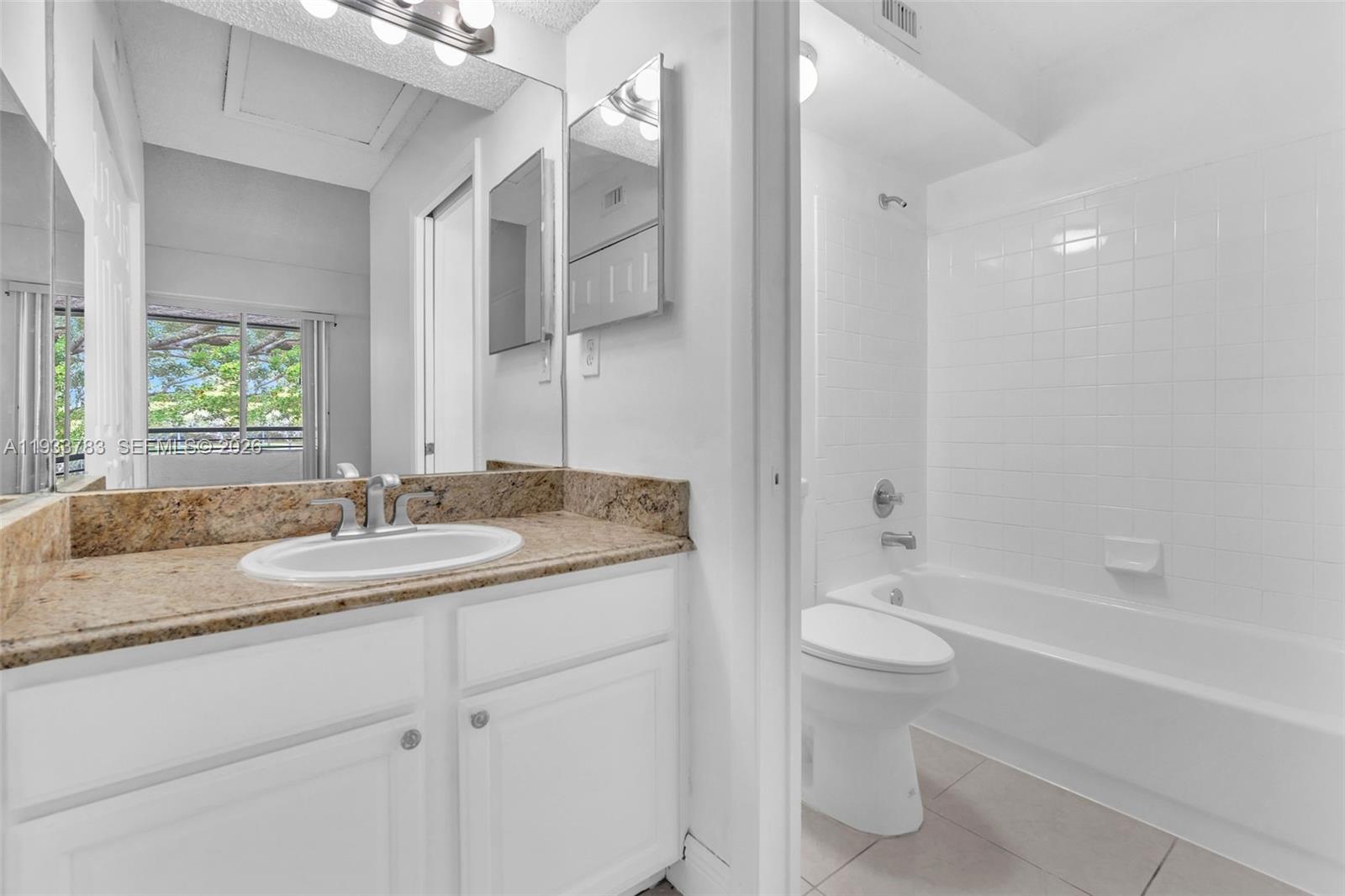 811 Lyons Road, Unit 20203 Coconut Creek, FL 33063 - Photo 15 of 21 a bathroom with a granite countertop sink toilet and shower