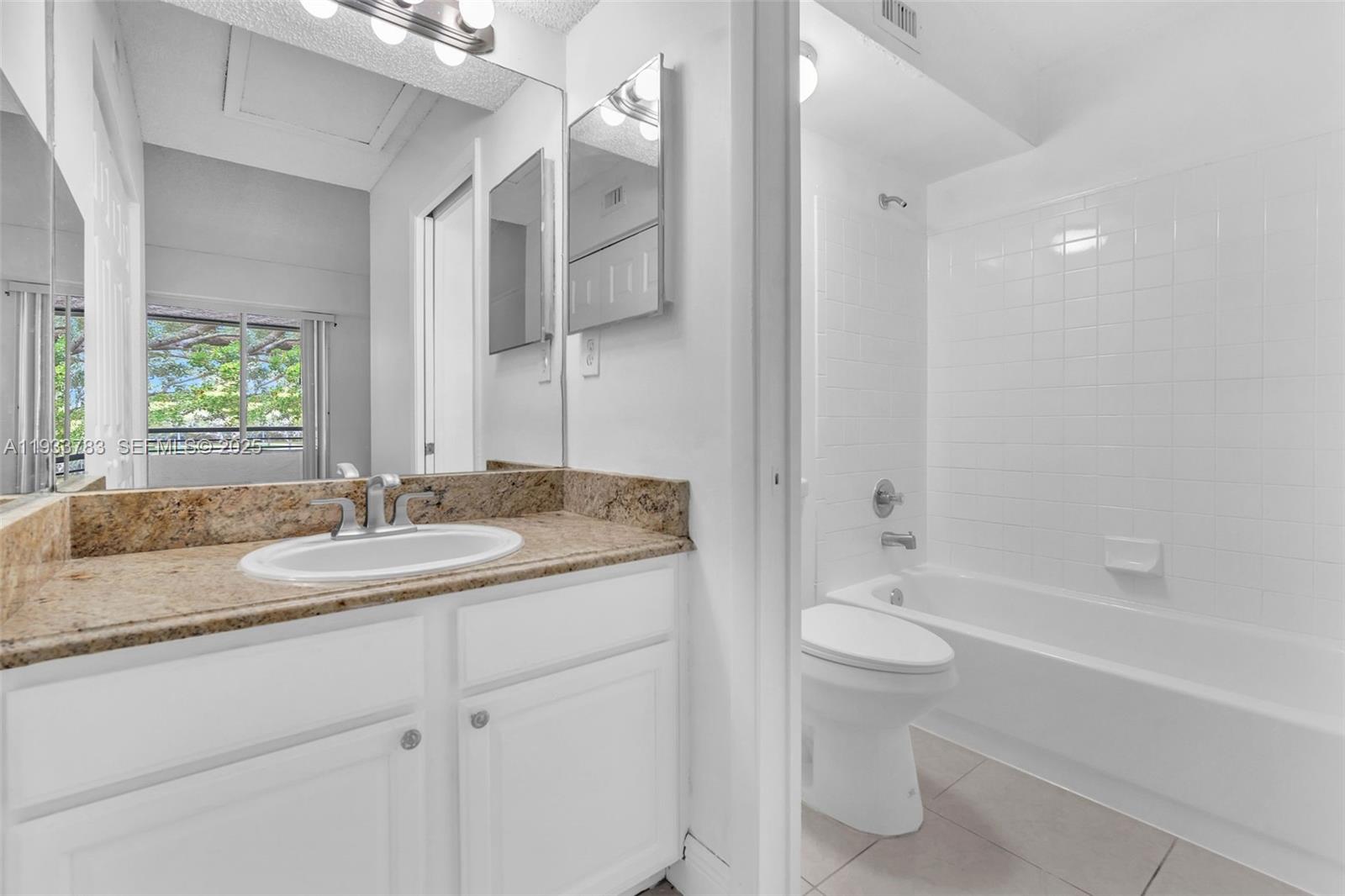 811 Lyons Road, Unit 20203 Coconut Creek, FL 33063 - Photo 17 of 23 a bathroom with a granite countertop sink toilet and shower
