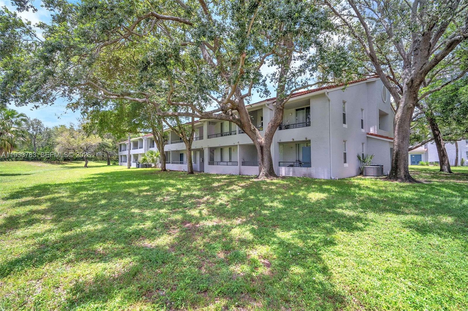 811 Lyons Road, Unit 20203 Coconut Creek, FL 33063 - Photo 19 of 21 a view of a house with yard and tree s
