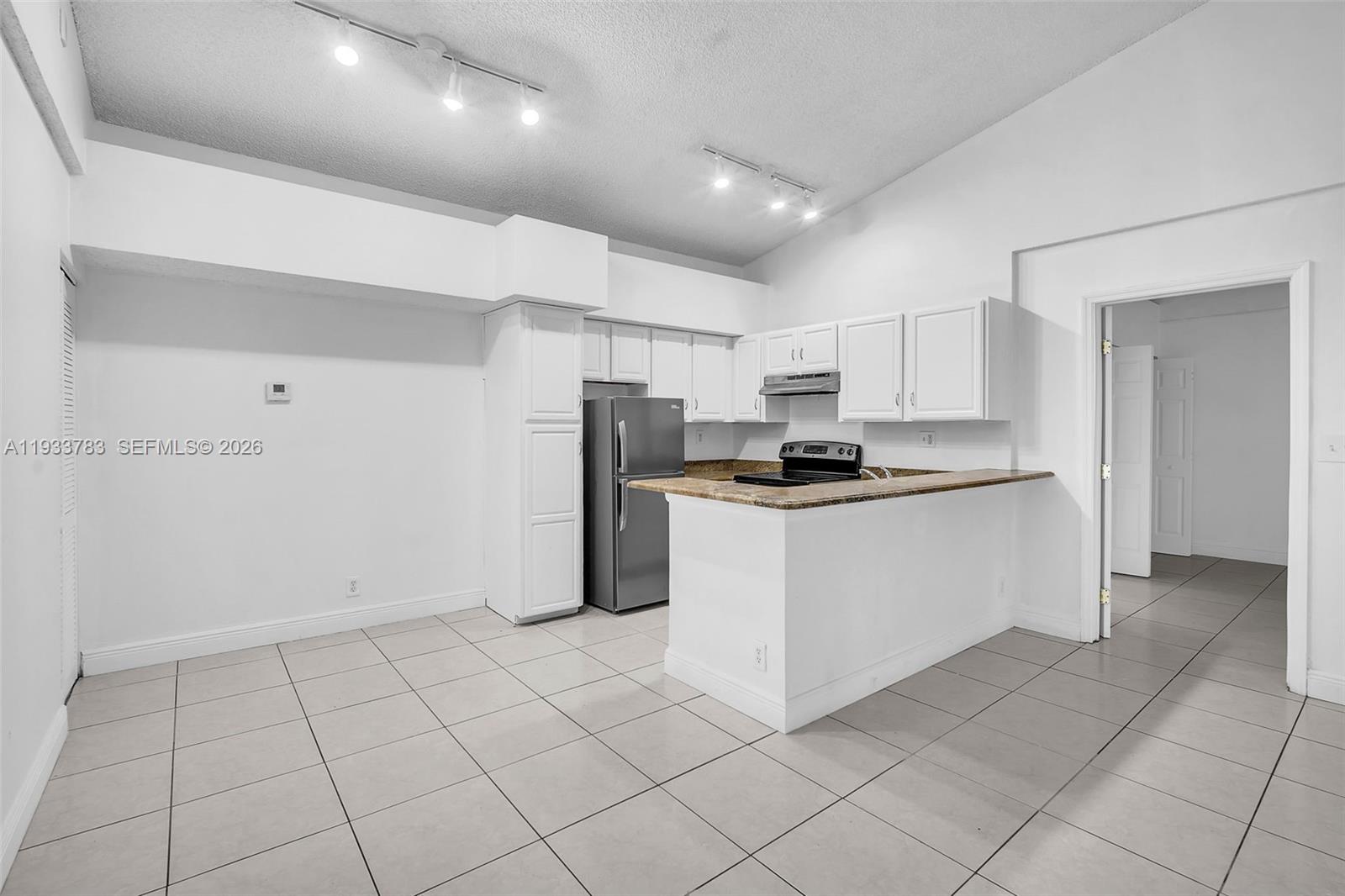 811 Lyons Road, Unit 20203 Coconut Creek, FL 33063 - Photo 7 of 21 a kitchen with cabinets and a refrigerator