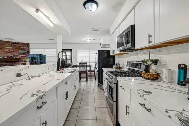 a kitchen with stainless steel appliances granite countertop a sink and cabinets
