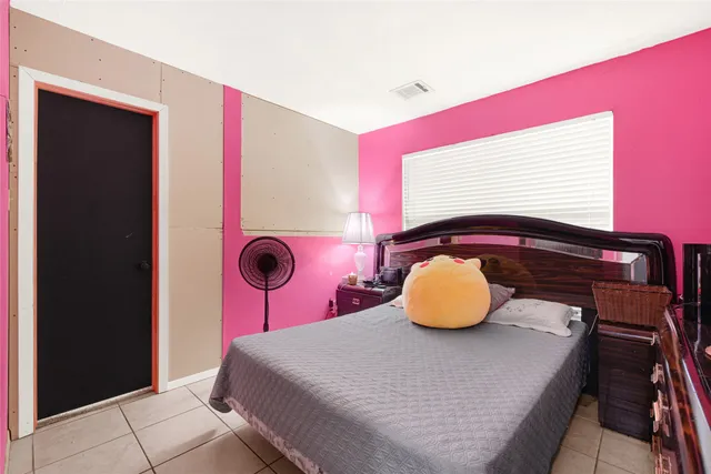 a bedroom with a bed and a potted plant