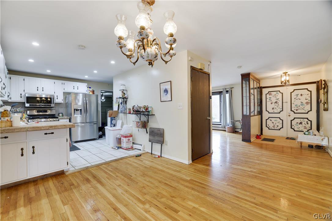 1493 Clover Road Long Pond, PA 18334 - Photo 6 of 36 a kitchen with stainless steel appliances granite countertop a refrigerator oven a sink dishwasher and white cabinets with wooden floor