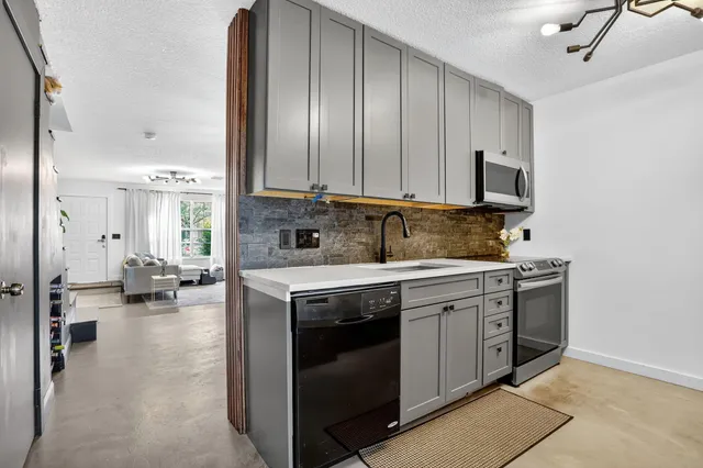 a kitchen with stainless steel appliances granite countertop a stove a sink and a refrigerator