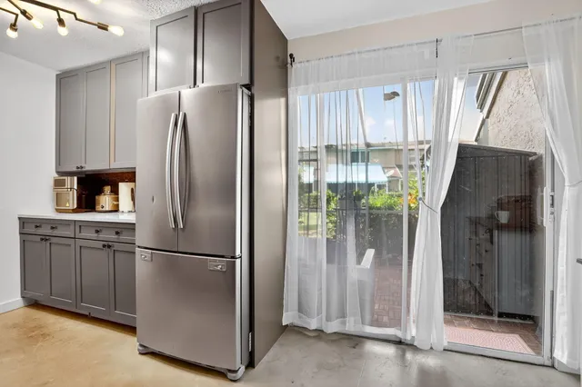 a metallic refrigerator freezer sitting in a kitchen