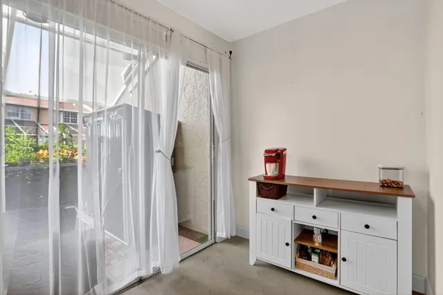 a view of kitchen with stainless steel appliances wooden floor and window