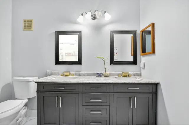 a bathroom with a granite countertop sink and a mirror