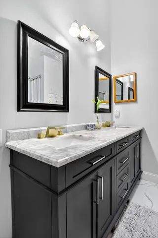 a bathroom with a toilet and a painting on the wall