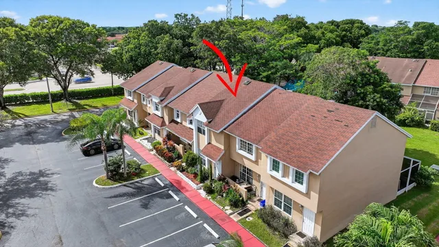 an aerial view of residential houses with outdoor space and trees