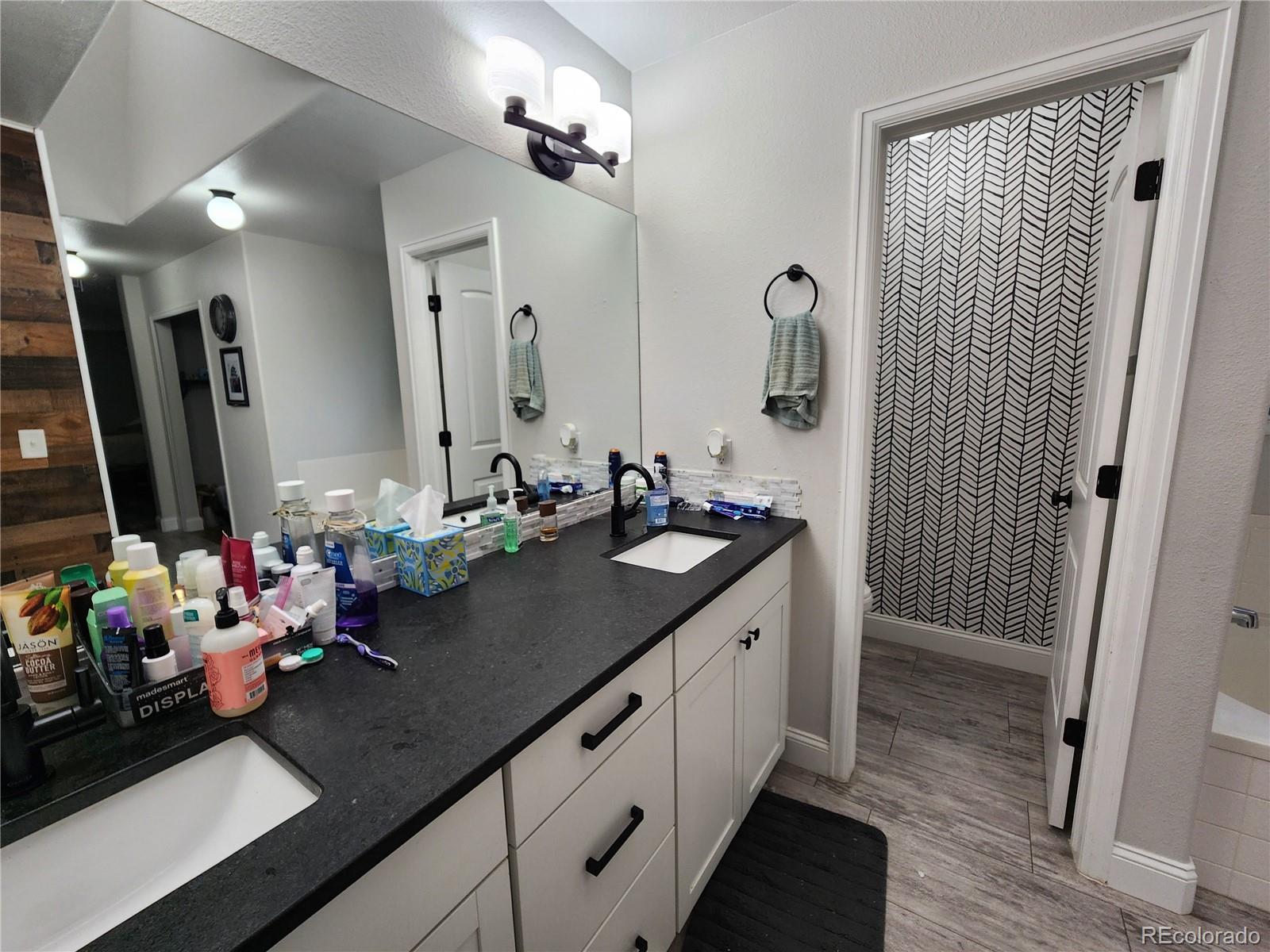 4745 Purcell Drive Colorado Springs, CO 80922 - Photo 13 of 25 a bathroom with a double vanity sink a mirror and shower