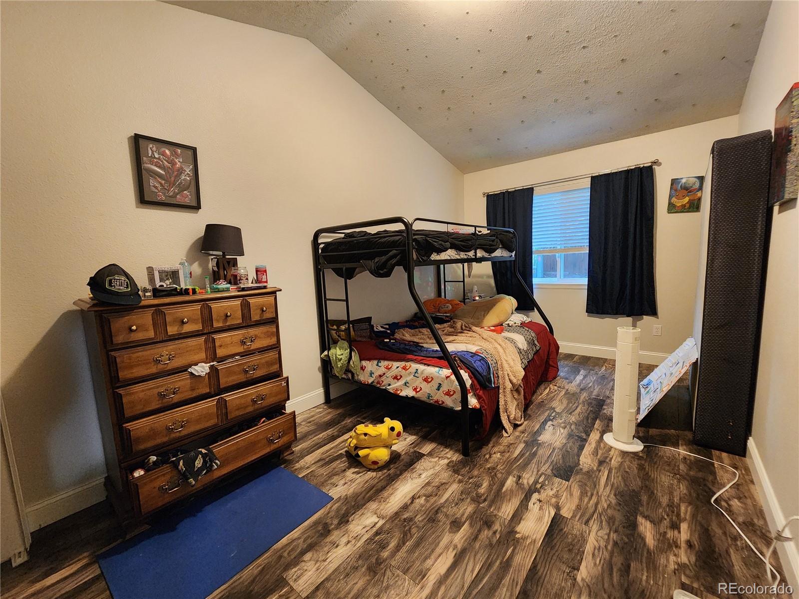 4745 Purcell Drive Colorado Springs, CO 80922 - Photo 18 of 25 a bedroom with a bed and wooden floor