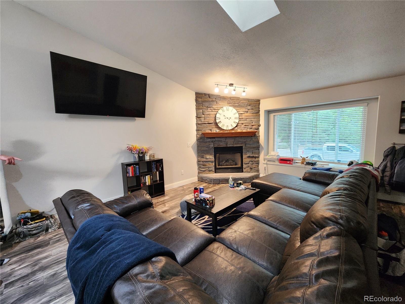 4745 Purcell Drive Colorado Springs, CO 80922 - Photo 4 of 25 a living room with furniture a flat screen tv and a fireplace
