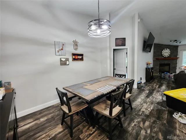 a view of a dining room with furniture a chandelier and wooden floor