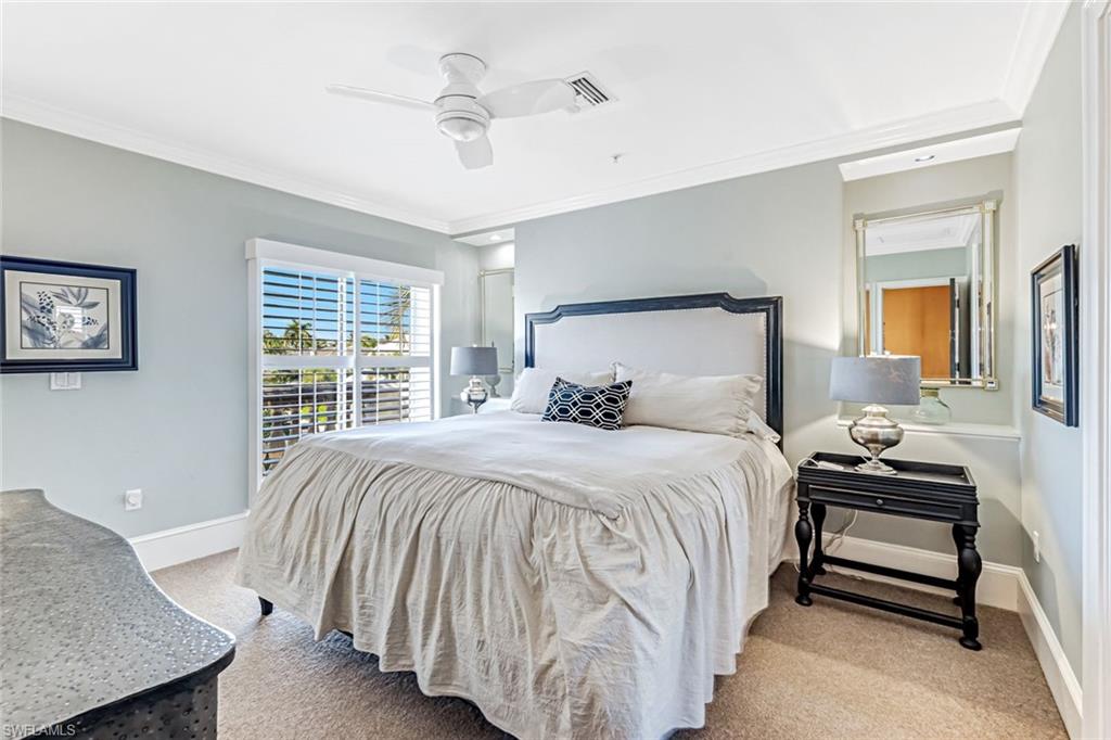 993 8th Street South, Unit 2 Naples, FL 34102 - Photo 14 of 28 a bedroom with a bed and a chandelier