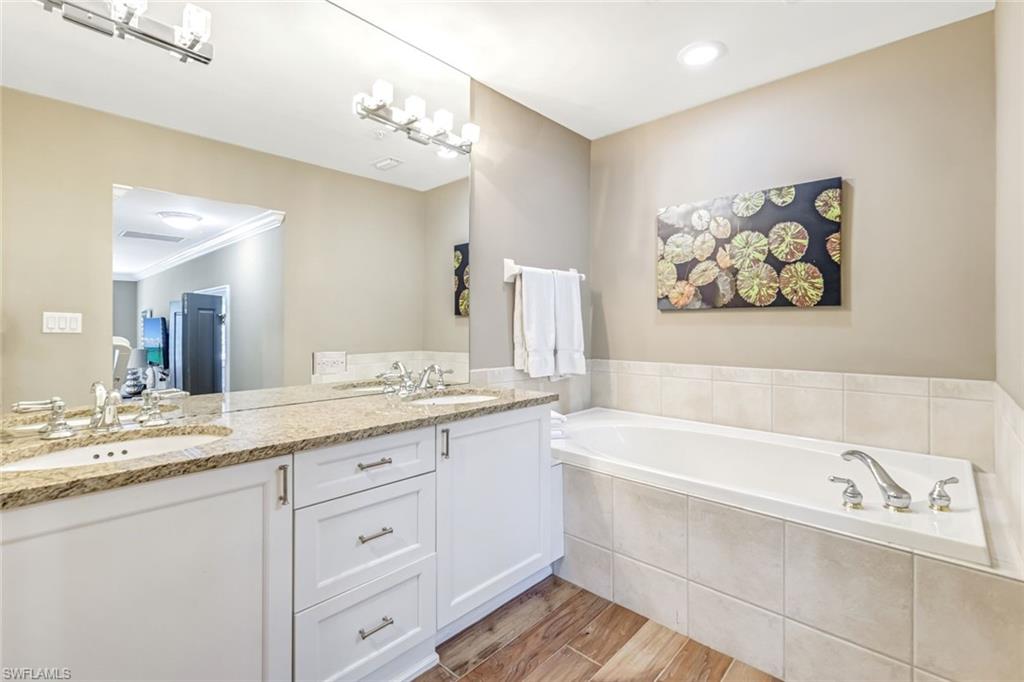 993 8th Street South, Unit 2 Naples, FL 34102 - Photo 15 of 28 a bathroom with a sink a bathtub and a mirror