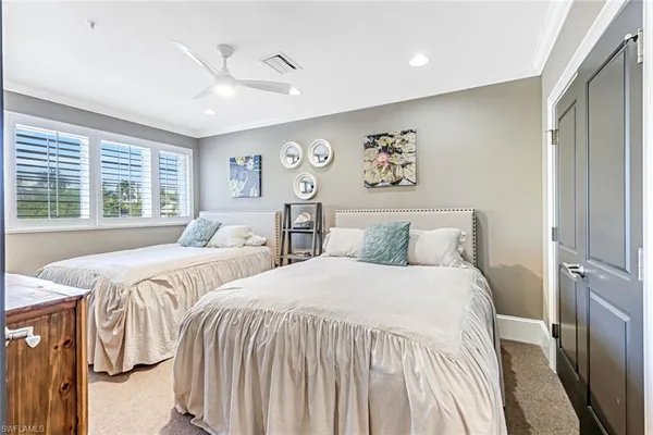 a bedroom with two beds and a large window