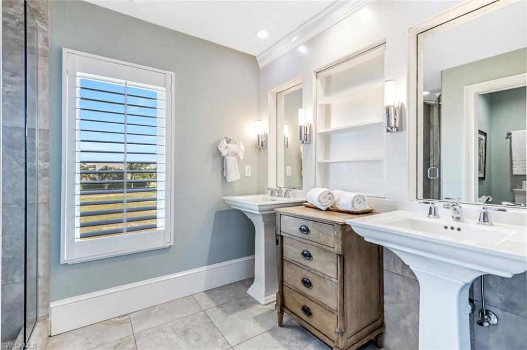 993 8th Street South, Unit 2 Naples, FL 34102 - Photo 17 of 28 a spacious bathroom with a double vanity sink a mirror and a bathtub