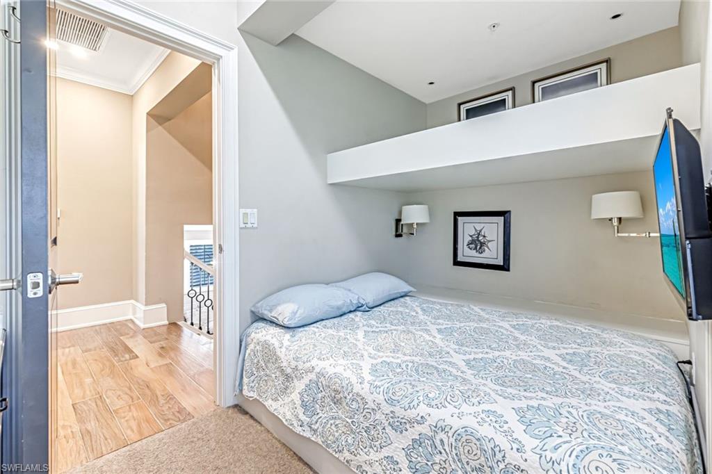 993 8th Street South, Unit 2 Naples, FL 34102 - Photo 19 of 28 a bedroom with a large bed and a large mirror