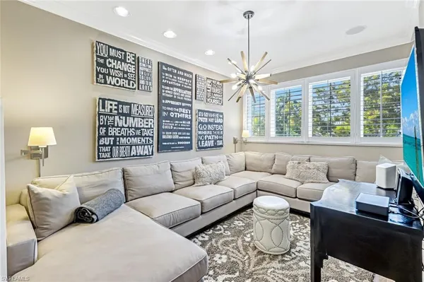 a living room with furniture a large window and a chandelier