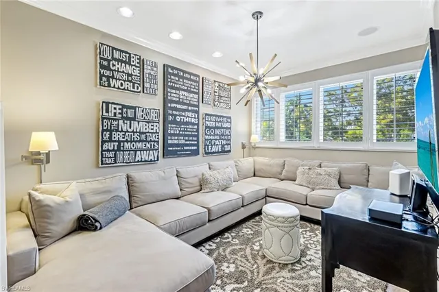 a living room with furniture a large window and a chandelier