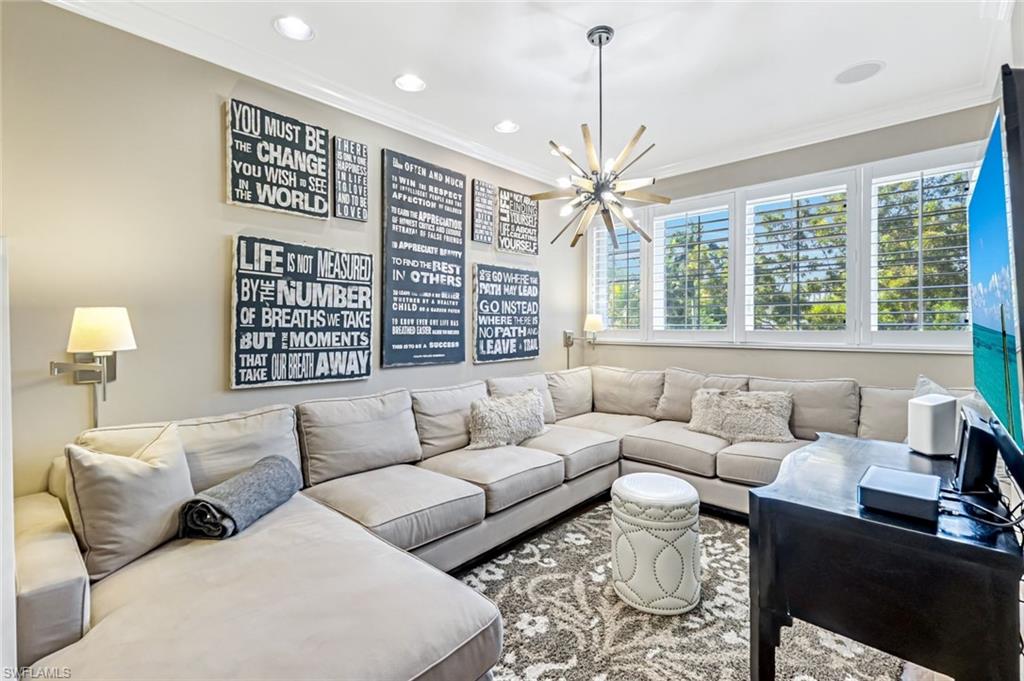 993 8th Street South, Unit 2 Naples, FL 34102 - Photo 21 of 28 a living room with furniture a large window and a chandelier