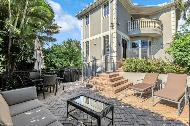 a view of a patio with couches table and chairs and potted plants