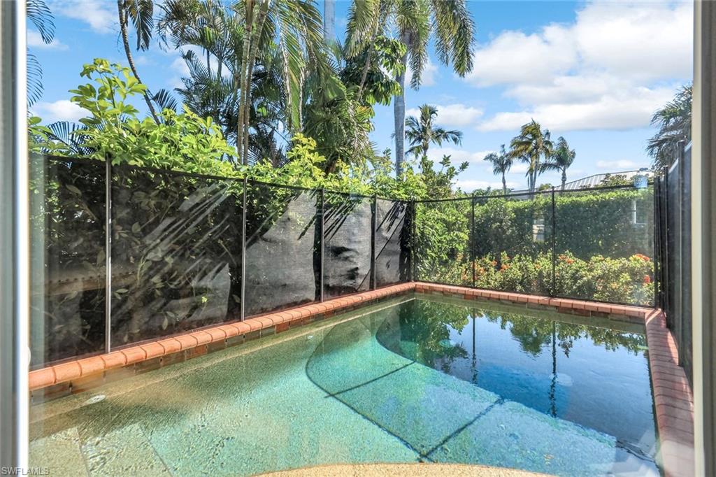 993 8th Street South, Unit 2 Naples, FL 34102 - Photo 25 of 28 a view of a swimming pool with a yard and sitting area