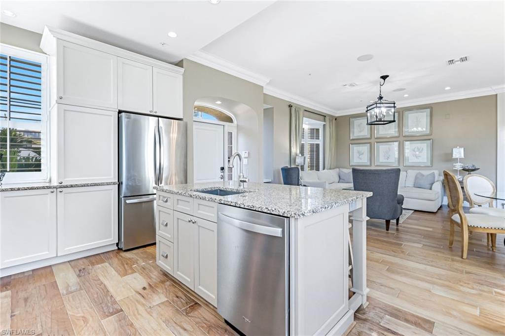 993 8th Street South, Unit 2 Naples, FL 34102 - Photo 8 of 28 a kitchen with kitchen island a sink stove and refrigerator