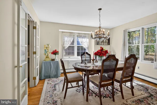 a dining room with furniture a chandelier and wooden floor