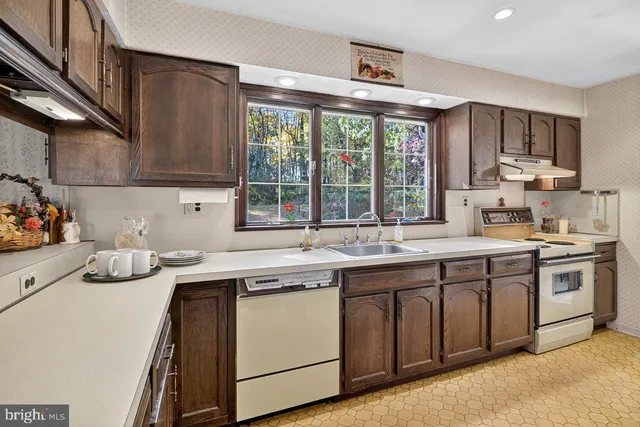 a kitchen with stainless steel appliances granite countertop a sink a stove and a refrigerator