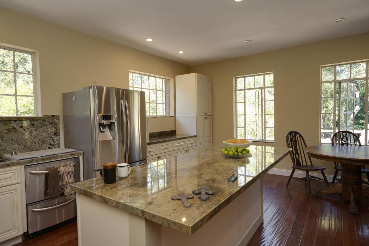 1438 Edgewood Road Redwood City, CA 94062 - Photo 4 of 9 a kitchen with stainless steel appliances granite countertop a refrigerator a stove a sink a dining table and chairs with wooden floor