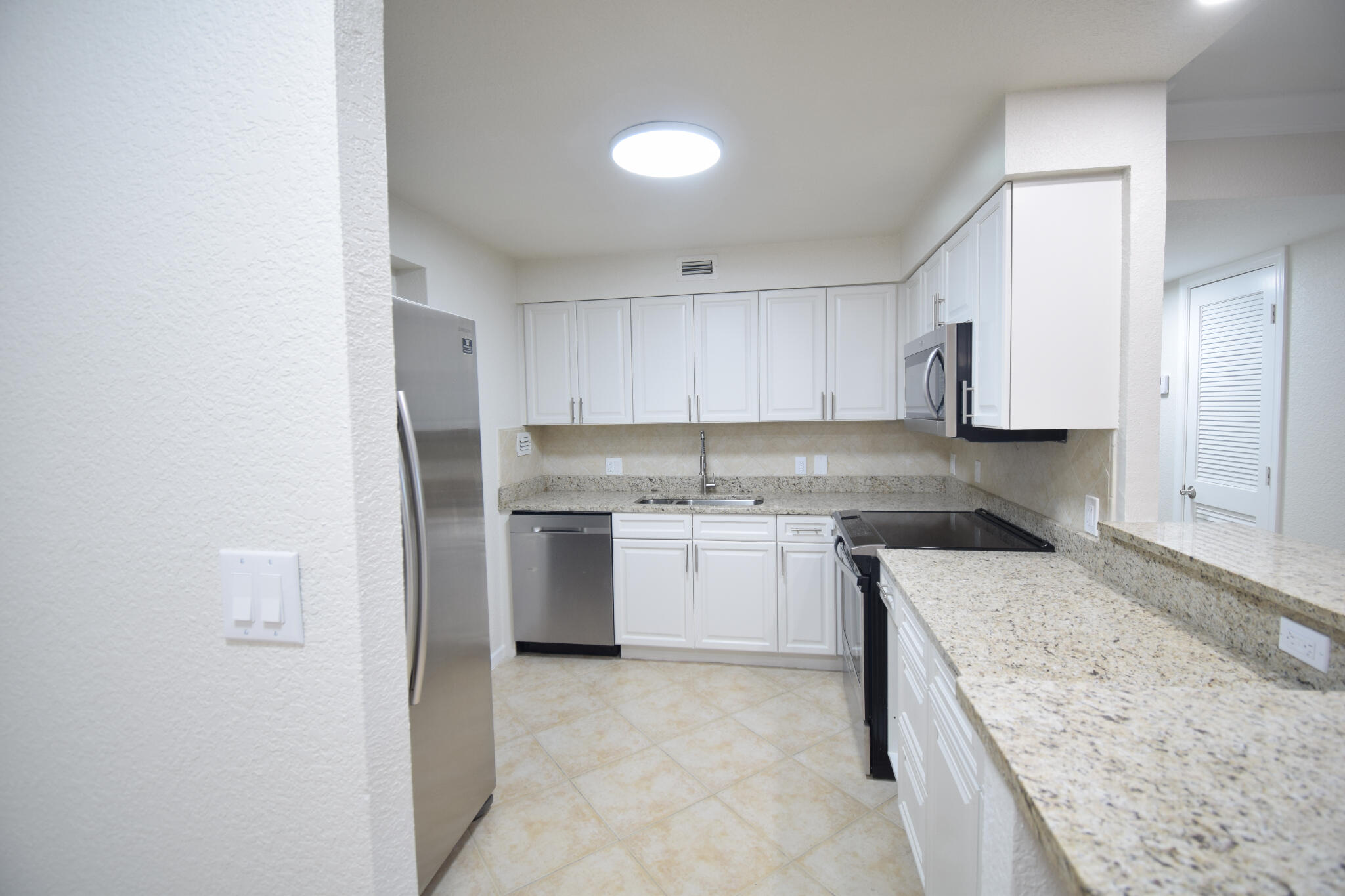 1000 Spanish River Road, Unit 2K Boca Raton, FL 33432 - Photo 7 of 26 a kitchen with a sink stove and refrigerator