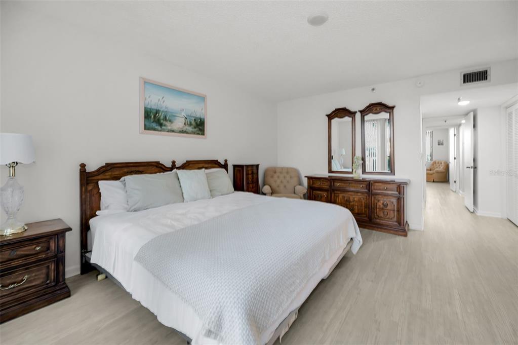 19111 Vista Bay Drive, Unit 211 Indian Shores, FL 33785 - Photo 30 of 62 a spacious bedroom with a bed and a chandelier