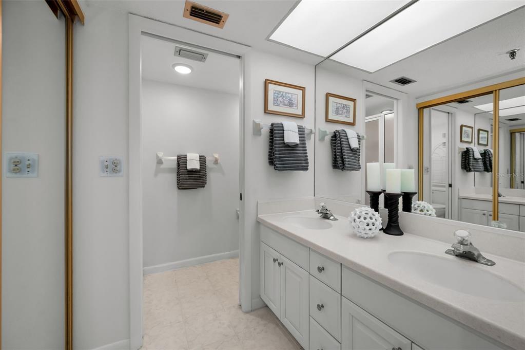 19111 Vista Bay Drive, Unit 211 Indian Shores, FL 33785 - Photo 31 of 62 a bathroom with double vanity sinks and a mirror