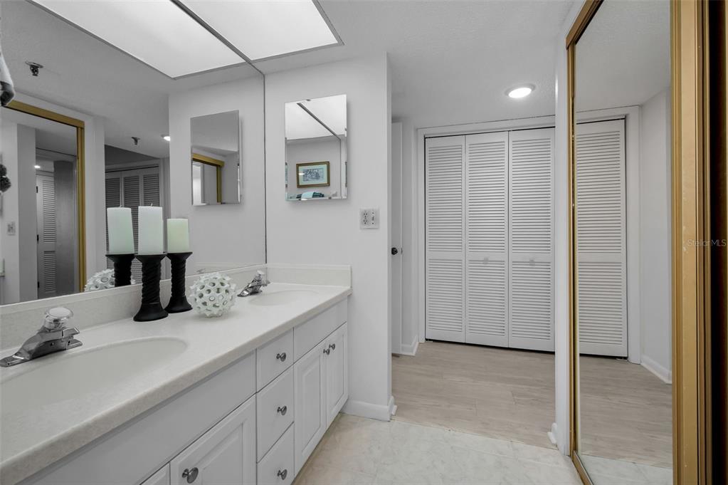 19111 Vista Bay Drive, Unit 211 Indian Shores, FL 33785 - Photo 33 of 62 a bathroom with a double vanity sink a mirror and a shower