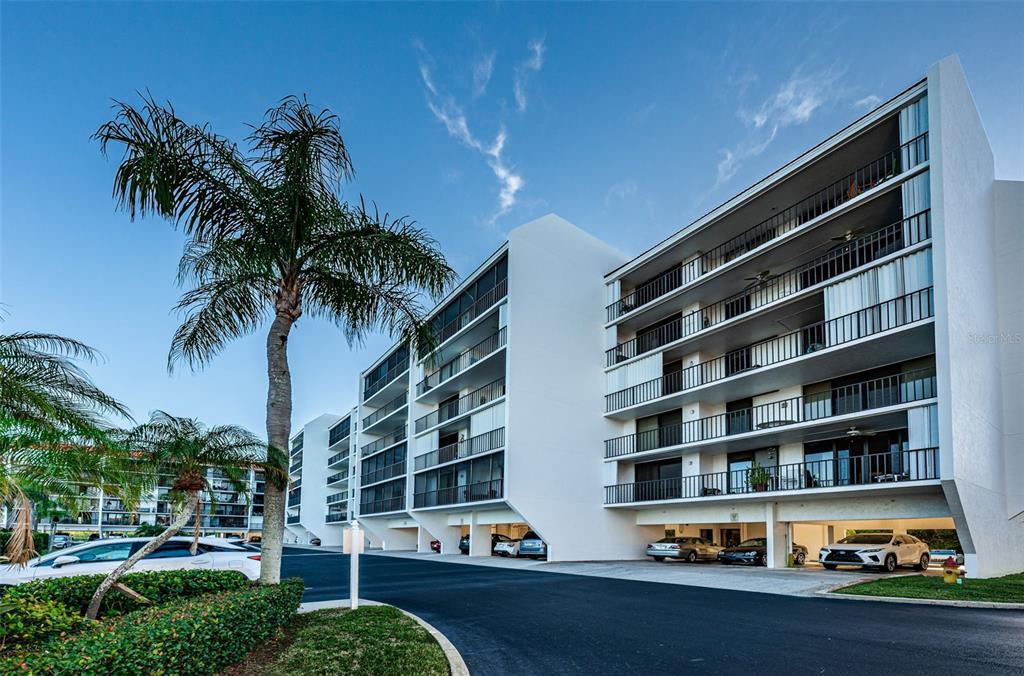 19111 Vista Bay Drive, Unit 211 Indian Shores, FL 33785 - Photo 4 of 62 a front view of multi story residential apartment building with yard and entryway