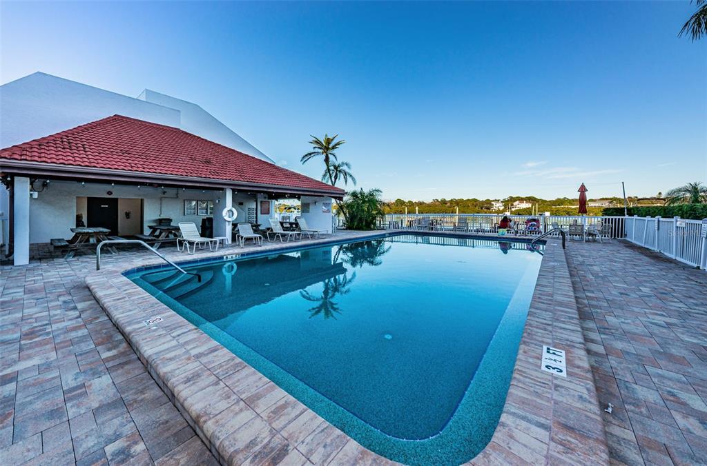 19111 Vista Bay Drive, Unit 211 Indian Shores, FL 33785 - Photo 52 of 62 a swimming pool with outdoor seating and yard