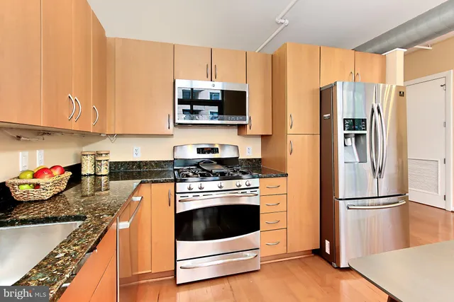 a kitchen with stainless steel appliances granite countertop a refrigerator stove and microwave