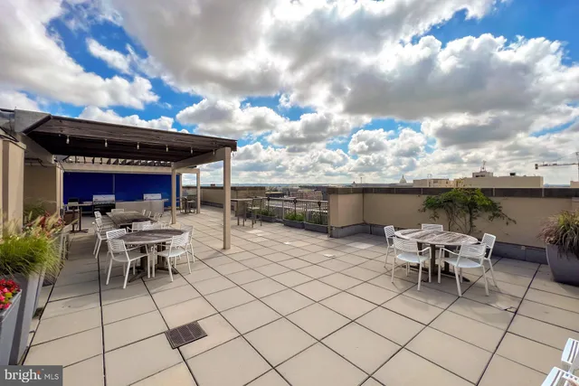 a view of a patio with dining table and chairs with a barbeque