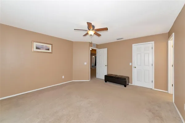 an empty room with closet and a ceiling fan