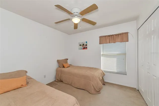 a bedroom with a bed and a ceiling fan