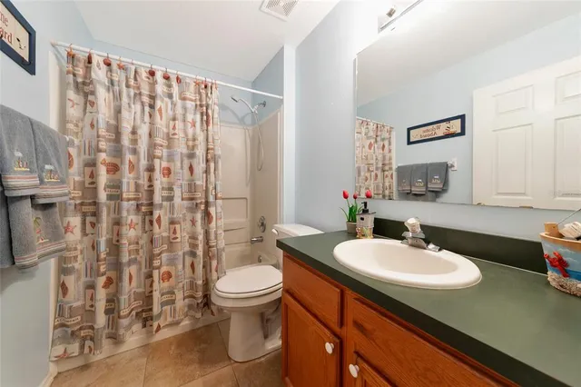 a bathroom with a sink a toilet and shower curtain