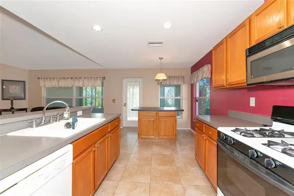 a large kitchen with stainless steel appliances a stove a sink dishwasher a microwave oven with cabinets