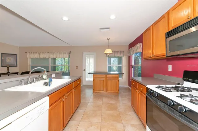 a large kitchen with stainless steel appliances a stove a sink dishwasher a microwave oven with cabinets