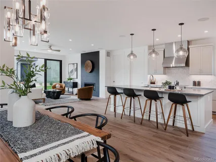 a kitchen with stainless steel appliances granite countertop a kitchen island a stove and a dining table with wooden floor