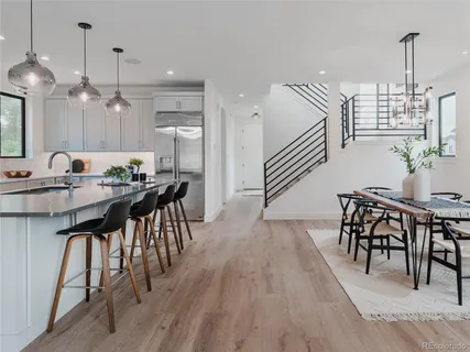 a kitchen with stainless steel appliances kitchen island granite countertop a table chairs sink and cabinets